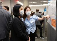 Two PhD students pointing to poster